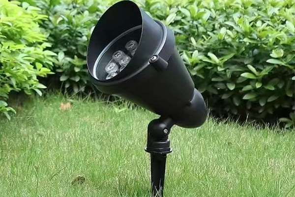 A close-up of a durable, IP65-rated outdoor light fixture in a garden setting.